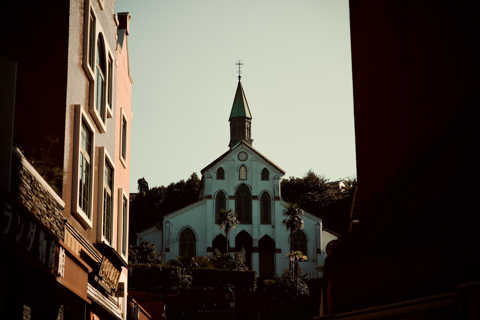 A white church with a steeple against a clear sky